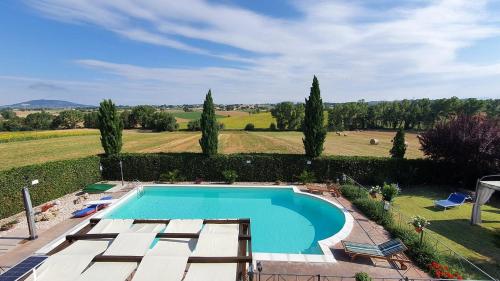 una imagen de una piscina en un jardín en Il Poggio del Sole, en Montefalco