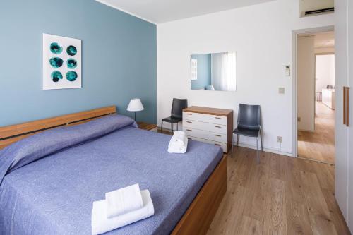 Schlafzimmer mit einem Bett, einem Schreibtisch und Stühlen in der Unterkunft Appartamento Calmo 1SX in Lido di Venezia