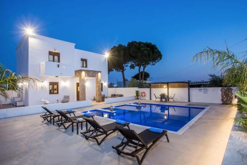 a villa with a swimming pool at night at MonaLisa Villa in Pefki Rhodes