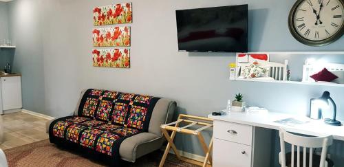 a room with a chair and a desk and a clock at Graceland Guesthouse in Potchefstroom