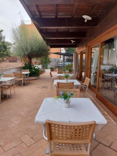 a patio with a white table and chairs and tables at Hotel Plammas in Santa Maria Navarrese