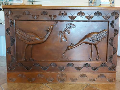 a wooden chest with a bronze bird on it at Hotel Plammas in Santa Maria Navarrese
