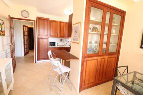 une cuisine avec des armoires en bois et une table et des chaises dans l'établissement 1 Bedroom Henri IV on the Croisette 240, à Cannes