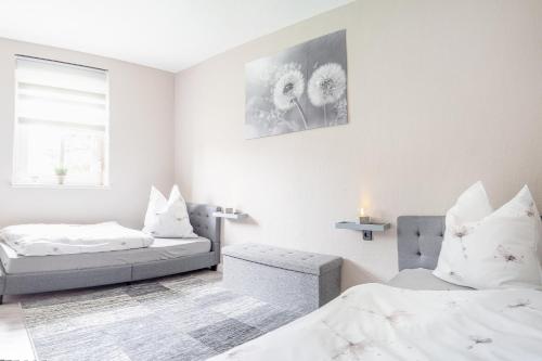 ein weißes Zimmer mit 2 Betten und einem Sofa in der Unterkunft Alva in Sondershausen