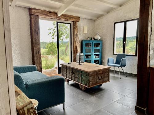 a living room with a couch and a coffee table at La Belle Petite Ferme Rosiers de Julliac 19350 in Les Bos