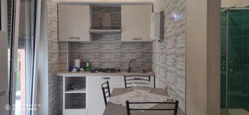 une petite cuisine avec une table et des chaises dans l'établissement B & B LE GEMELLINE, à Salerne