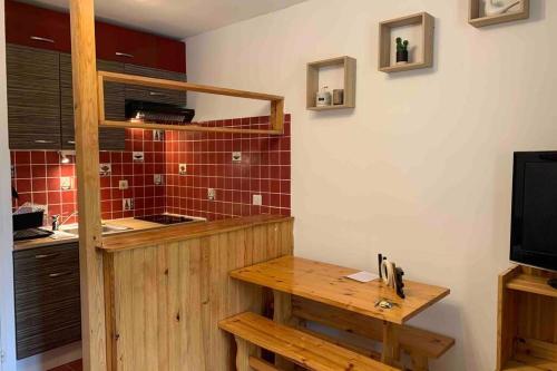 eine Küche mit einem Holztisch im Zimmer in der Unterkunft Studio chaleureux et ensoleillé ! in Allos