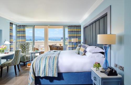 una camera d'albergo con un letto, una scrivania e una stanza di The Eliott Hotel a Gibilterra