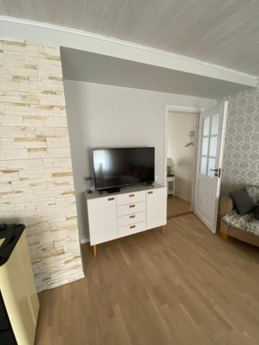 a living room with a television on a white cabinet at Tamula apartament in Võru