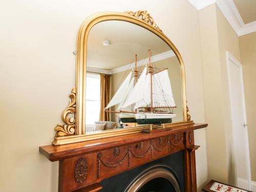 un espejo sobre una chimenea con un barco. en Regent House en Scarborough