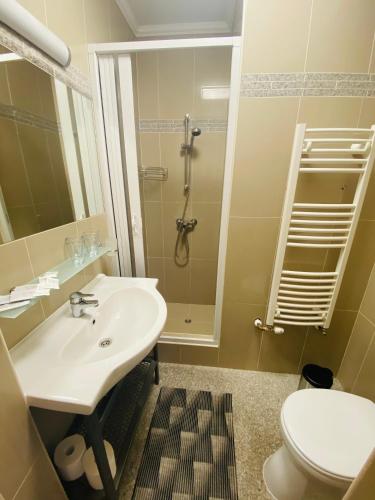 a bathroom with a sink and a shower and a toilet at Linton Apartmanház - Siófok, Plázs in Siófok