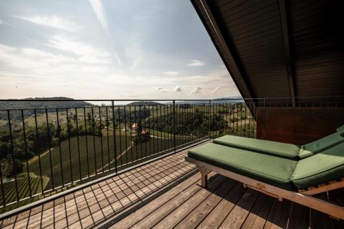 a balcony with a bench and a view of the water at Weinhotel Maitz Wolfgang in Ratsch an der Weinstraße