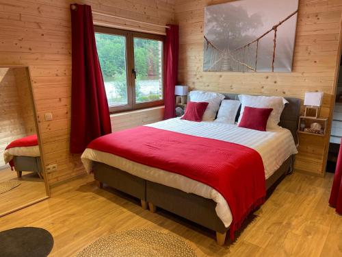 1 dormitorio con 1 cama grande con manta roja en La Petite Maison au bord de l'eau, en Hastière-par-delà