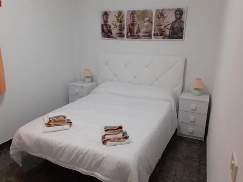 een slaapkamer met een wit bed en 2 handdoeken bij CASA LALI in Alojera