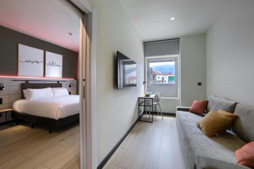 a living room with a bed and a couch at Hotel Bed4U Bilbao in Bilbao