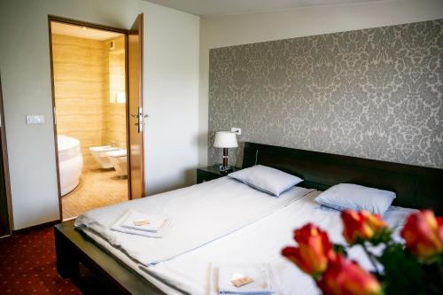 a bedroom with a bed and a bathroom with a tub at Kamionki in Sosnowiec