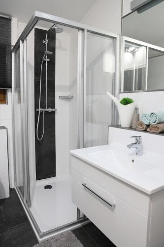 a white bathroom with a shower and a sink at Ferienwohnung - Nähe Kaiserslautern in Trippstadt
