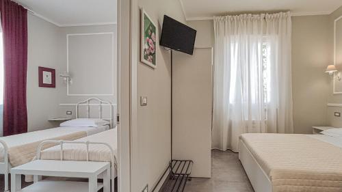a hotel room with two beds and a window at LA DAMA ROOM&BREAKFAST in Russi