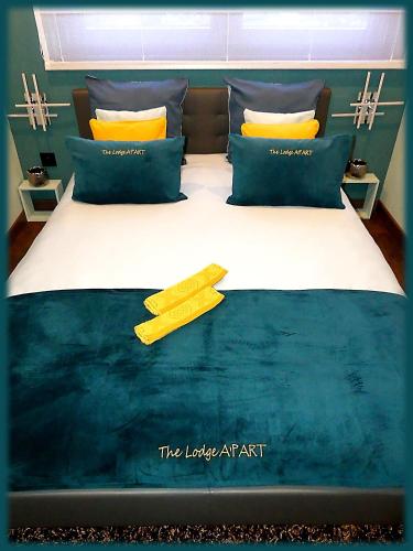 une chambre avec un grand lit avec des oreillers jaunes dans l'établissement The Lodge A'PART, à Néewiller-près-Lauterbourg