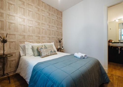 1 dormitorio con 1 cama con manta azul en Magno Apartments Feijóo, en Sevilla