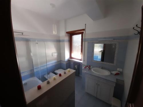 łazienka z 2 umywalkami, wanną i lustrem w obiekcie DreamHouse w mieście LʼAquila