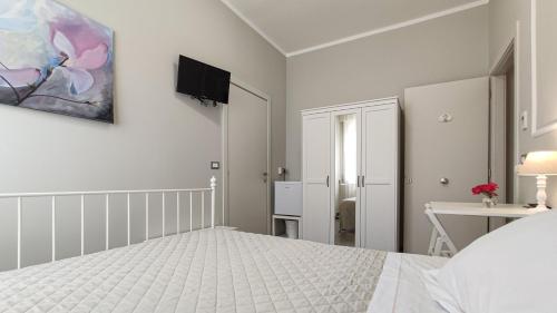 a white bedroom with a bed and a tv on the wall at LA DAMA ROOM&BREAKFAST in Russi