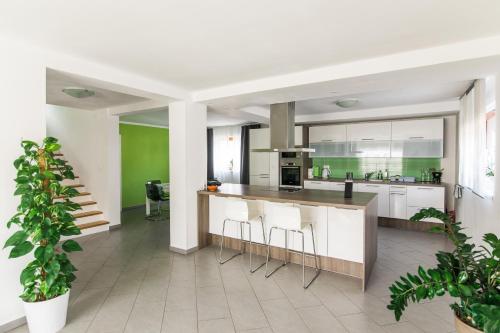 an open kitchen with white cabinets and bar stools at Pr' Petrču in Tolmin