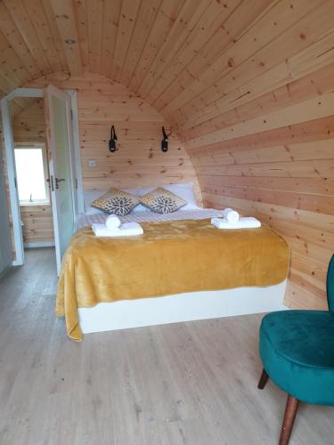 ein Schlafzimmer mit einem Bett in einem Holzzimmer in der Unterkunft Berehaven Pods in Castletownbere