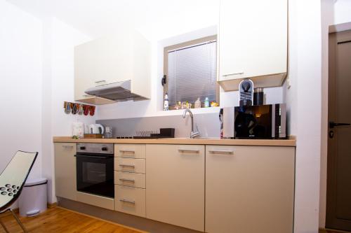 a kitchen with white cabinets and a sink at Charming apartment near beach in Sveti Stefan
