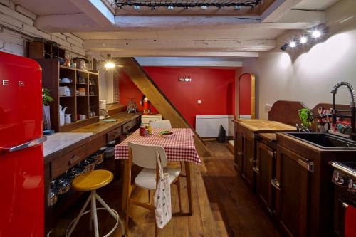 une cuisine avec une table et un mur rouge dans l'établissement Gîte - L'atelier au 19, à Ernolsheim-Bruche