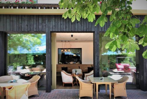 un restaurante con mesas, sillas y ventanas grandes en Hotel Residence der bircher, en Campo di Trens