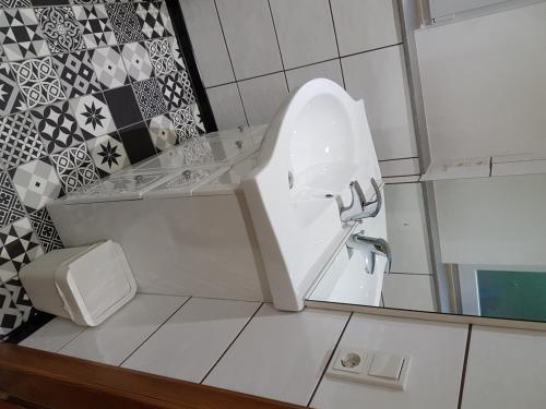 une salle de bain avec un lavabo et un miroir dans l'établissement Les Dames de la Montagne, à Frauenberg