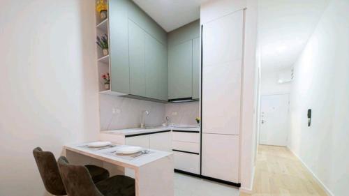 a kitchen with white cabinets and a table and chairs at DiVa Lux Apartment in Soho City complex in Bar