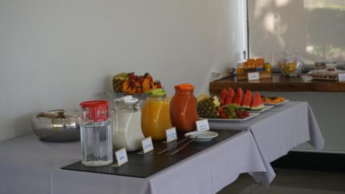 イタウナにあるHotel Lago do Solの果物とジュースと食べ物の皿が置かれたテーブル