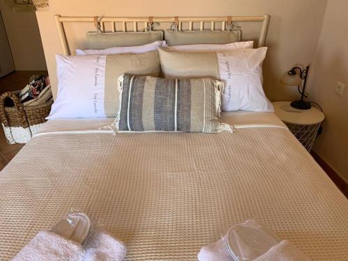 a bedroom with a large bed with white pillows at Kalamavros nature home - Kythoikies holiday houses in Kythira