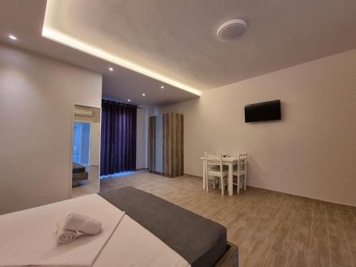 a bedroom with a bed and a table and a television at Imperial Hotel in Shënkoll