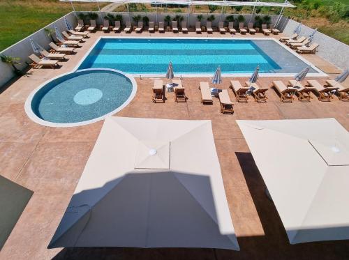 una vista sul soffitto di una piscina con sedie e una piscina di Imperial Hotel a Shënkoll