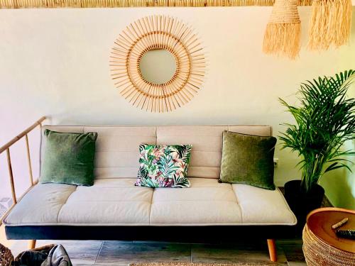 a couch with pillows in a living room with a mirror at Casa Julia with swimming pool in Cautivador