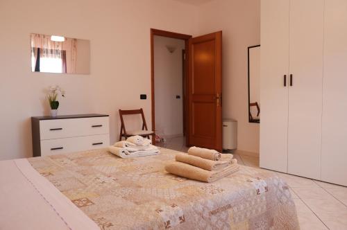 a bedroom with a bed with towels on it at Casa DàCà in Marrùbiu