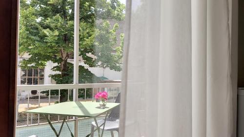 a table with a pink flower in a vase next to a window at LA DAMA ROOM&BREAKFAST in Russi