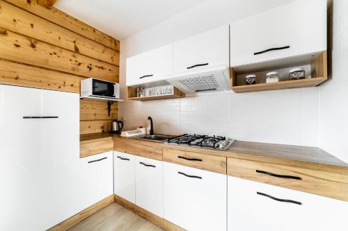 a kitchen with white cabinets and a stove at Domek u Stochów in Biały Dunajec