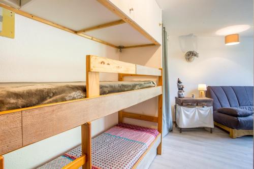 Etagenbett in einem Zimmer mit Sofa in der Unterkunft L'Eclose - Alpe d'Huez in Huez