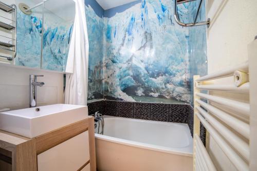 ein Badezimmer mit einem Waschbecken, einer Badewanne und einer Dusche in der Unterkunft L'Eclose - Alpe d'Huez in Huez