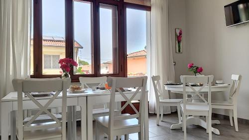 a white dining room with a table and chairs at LA DAMA ROOM&BREAKFAST in Russi