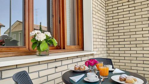 a table with two plates of food and a vase of flowers at LA DAMA ROOM&BREAKFAST in Russi