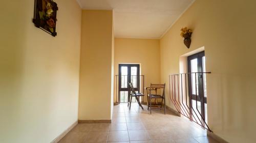 a hallway with yellow walls and a table and chairs at Saint George Hotel & Medical Spa in Pomorie