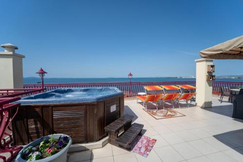 a hot tub on a balcony with chairs and tables at Saint George Hotel & Medical Spa in Pomorie