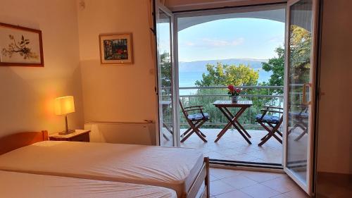 ein Schlafzimmer mit Bett und Balkon mit Aussicht in der Unterkunft Sea Side Apartments 4* in Novi Vinodolski