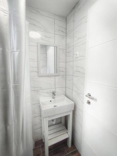 a white bathroom with a sink and a shower at Aria Plitvice in Plitvička Jezera