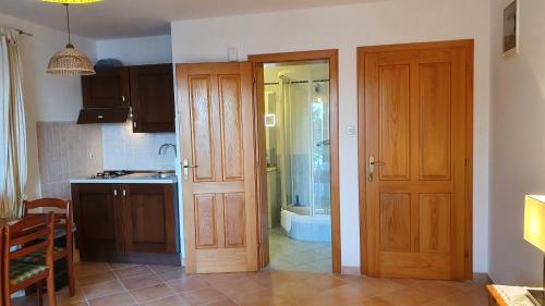 eine Küche mit zwei Holztüren und einer Dusche in der Unterkunft Sea Side Apartments 4* in Novi Vinodolski